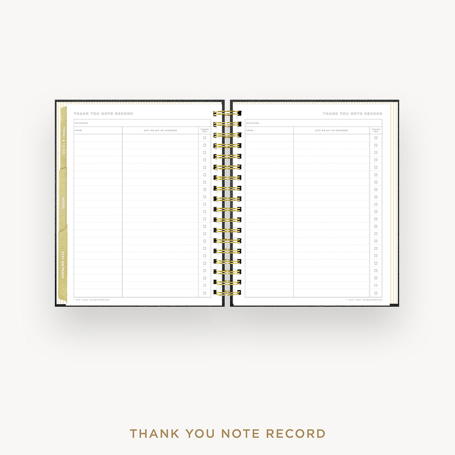 An open spiral-bound thank you note record planner with white pages, gold wire binding, and gold tab accents, shown on a light gray background with the text 'THANK YOU NOTE RECORD' below.