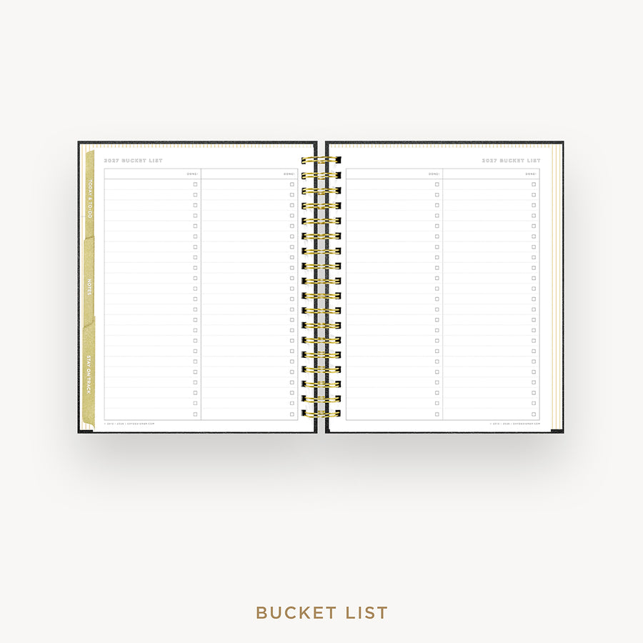 An open spiral-bound bucket list planner shown from above on a light gray background, with gold text reading 'BUCKET LIST' below.