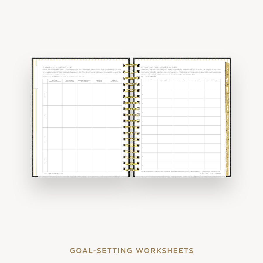 An open spiral-bound planner or notebook showing two printed goal-setting worksheet pages, with a gold wire binding and a gold page accent on the right side, photographed on a light gray background. Text below reads 'GOAL-SETTING WORKSHEETS'.