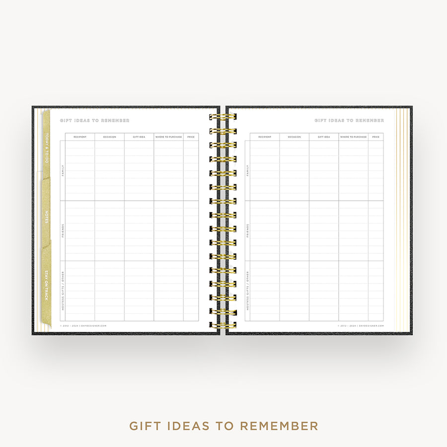 An open spiral-bound planner or notebook showing a gift ideas to remember page spread, with gold-toned binding and a light neutral background. Text below reads 'GIFT IDEAS TO REMEMBER'.