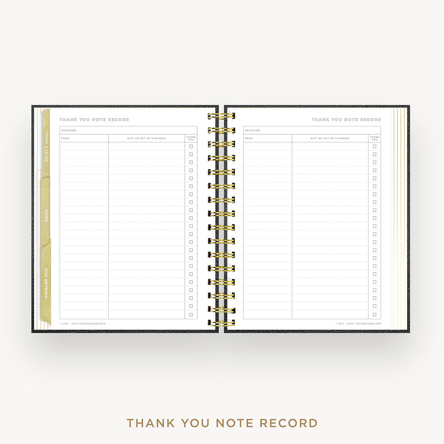 An open spiral-bound thank you note record planner on a light beige background. The pages are white with gold and black text and lines, and the center binding is gold.