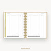 An open spiral-bound planner or notebook showing a clean expenses page layout with lined tables, gold ring binding, and a gold page edge, centered on a light gray background with the word EXPENSES below.