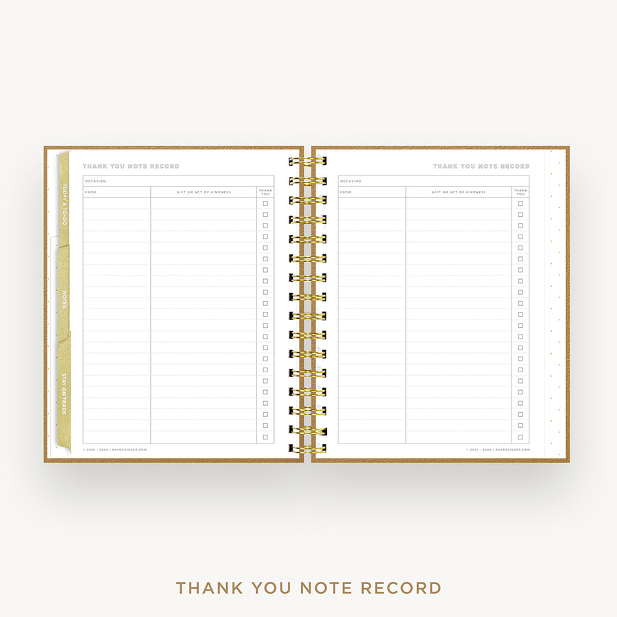 An open spiral-bound thank you note record planner on a light gray background. The pages are white with gold lines and gold tabs, and the gold metal spiral binding is clearly visible.