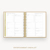 An open spiral-bound planner or checklist book showing two printed pages titled 'ENTERTAINMENT CHECKLIST' on a light gray background. The pages are white with fine gray lines and small gold accents, including a gold vertical tab on the left margin and gold spiral rings.