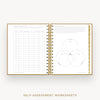 An open spiral-bound workbook showing self-assessment worksheet pages, including a table on the left and a Venn diagram on the right, with gold rings and a gold border. The text 'SELF-ASSESSMENT WORKSHEETS' appears below on a light background.
