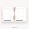 An open spiral-bound planner showing two blank expense pages with gold rings and a light pink border, on a light gray background with the word EXPENSES below.