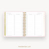 An open planner or notebook showing a favorites list page spread, with lined sections, checkboxes, and a gold spiral binding on a light gray background. The text 'FAVORITES LIST' appears below the product.