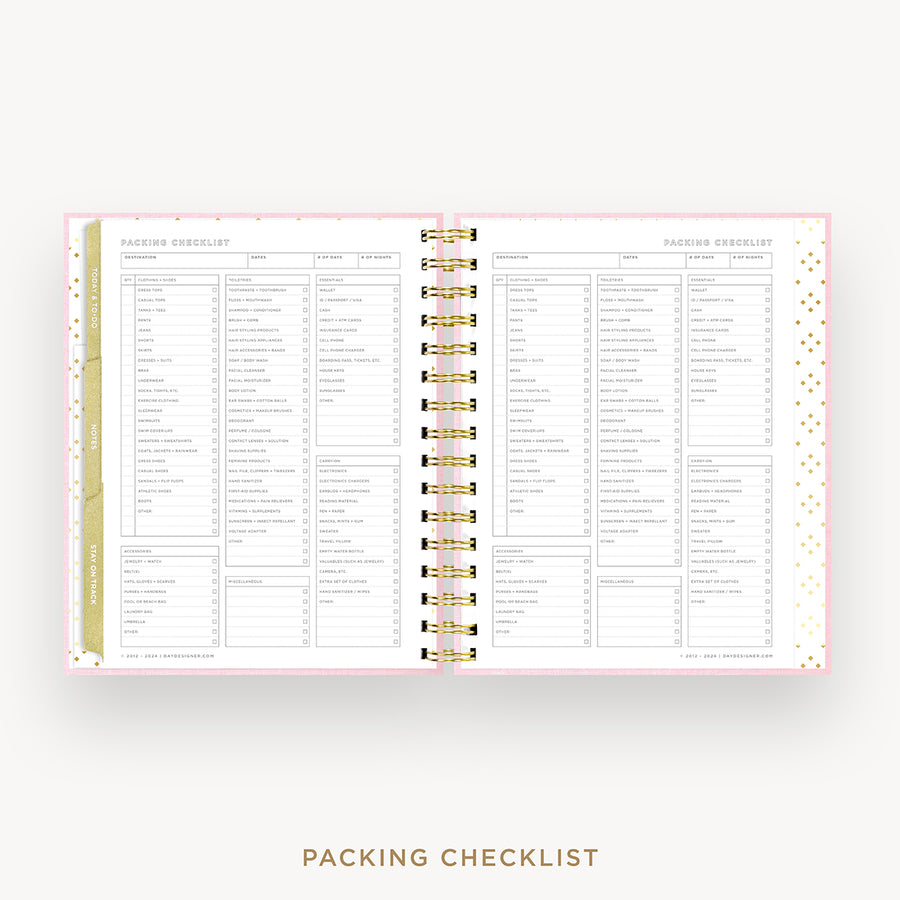 An open spiral-bound planner or notebook showing a packing checklist page spread across both pages, with a pale pink border, gold rings, and a gold vertical tab on the left. The words 'PACKING CHECKLIST' appear below the product on a light gray background.