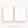 An open spiral-bound planner or checklist book showing two printed pages titled 'ENTERTAINMENT CHECKLIST' on a light gray background. The pages are white with fine pink border lines, small gold confetti dots, and gold-and-white spiral binding.