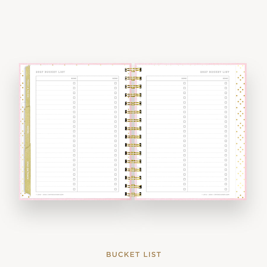 An open spiral-bound planner or notebook showing a 'Bucket List' page layout with lined sections, checkboxes, and decorative gold polka dots on a white page, set against a light gray background with the words 'BUCKET LIST' below.