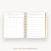 An open spiral-bound planner or notebook showing two pages of goal-setting worksheets with pink borders, gold polka dots, and gold ring binding, on a light gray background with the text 'GOAL-SETTING WORKSHEETS' below.