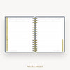 An open spiral-bound planner or notebook showing lined notepad pages, with gold and black spiral binding and small gold tabs, on a light gray background. The text 'NOTES PAGES' appears below.