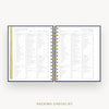An open spiral-bound planner or notebook showing two printed checklist pages titled 'Packing Checklist,' with a gold-toned ring binder and a narrow gold vertical tab on the left page, set against a light gray background with the words 'Packing Checklist' below.