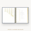 An open spiral-bound planner or pocket organizer shown on a light gray background, with gold foil text and divider pages inside. The bottom text reads 'POCKET, STICKERS AND RULER'.