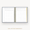 An open spiral-bound planner or notebook showing two pages of goal-setting worksheets with gold rings, on a light gray background with the text 'GOAL-SETTING WORKSHEETS' below.