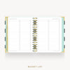 An open spiral-bound planner or notebook showing a bucket list page layout with lined sections and checkboxes, gold rings, and pastel side accents on a light gray background.