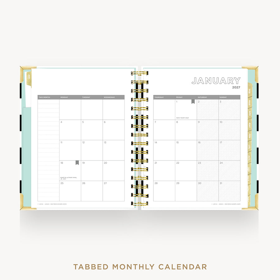 An open tabbed monthly calendar planner shown from above on a light gray background. The pages are white with gold spiral binding and a mint green left tab.