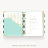 An open pocket planner with gold-tone spiral rings, white pages, a mint pocket, and gold text accents. The text below reads 'POCKET, STICKERS AND RULER'.