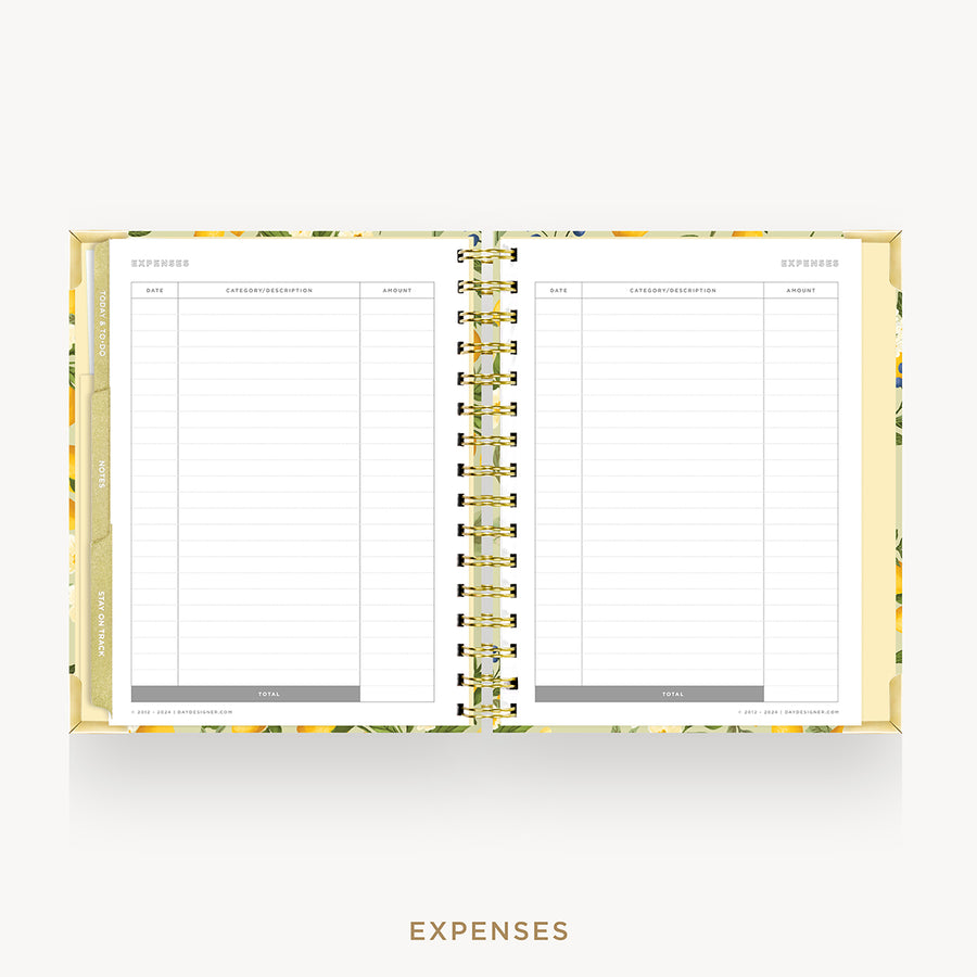An open spiral-bound planner or notebook showing lined expense pages on both sides, with a floral-patterned cover and gold-toned rings, centered on a light gray background with the word EXPENSES below.