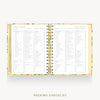 An open spiral-bound planner or notebook showing a packing checklist page spread across both sides, with a gold-toned spiral and a light floral-patterned cover on a white background.