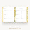An open spiral-bound planner showing weekly planning pages with floral-patterned gold and yellow borders, photographed on a light gray background with the text 'WEEKLY PLANNING PAGE' below.