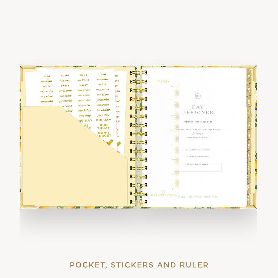 An open Day Designer pocket planner with a floral-patterned cover, gold spiral binding, a pocket, sticky notes, and a ruler, shown on a light gray background with the text 'POCKET, STICKERS AND RULER' below.