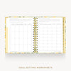 An open spiral-bound planner or notebook showing two pages of goal-setting worksheets, with a floral patterned cover and gold spiral binding on a light gray background. Text below reads 'GOAL-SETTING WORKSHEETS'.