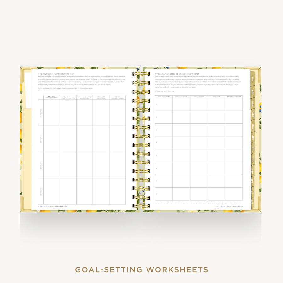 An open spiral-bound planner or notebook showing two pages of goal-setting worksheets, with a floral patterned cover and gold spiral binding on a light gray background. Text below reads 'GOAL-SETTING WORKSHEETS'.