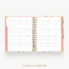 An open 12-month spiral planner or calendar with white pages showing monthly grids, a pink cover edge, and a floral-patterned cover, photographed on a light gray background with the text '12-MONTH OVERVIEW' below.
