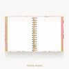 An open spiral-bound planner or notebook showing lined white notes pages, with a pastel pink floral cover and gold-toned spiral binding on a light gray background. The text 'NOTES PAGES' appears below.