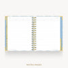 An open spiral-bound planner or notebook with lined pages, shown on a light gray background. The cover and edges have a pale blue and white patterned design with gold-toned spiral binding.