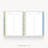 An open spiral-bound planner or agenda showing two lined pages labeled 'FAVORITES LIST' on a light gray background. The cover and inner borders have a pale blue and white pattern, and the spiral binding is gold.