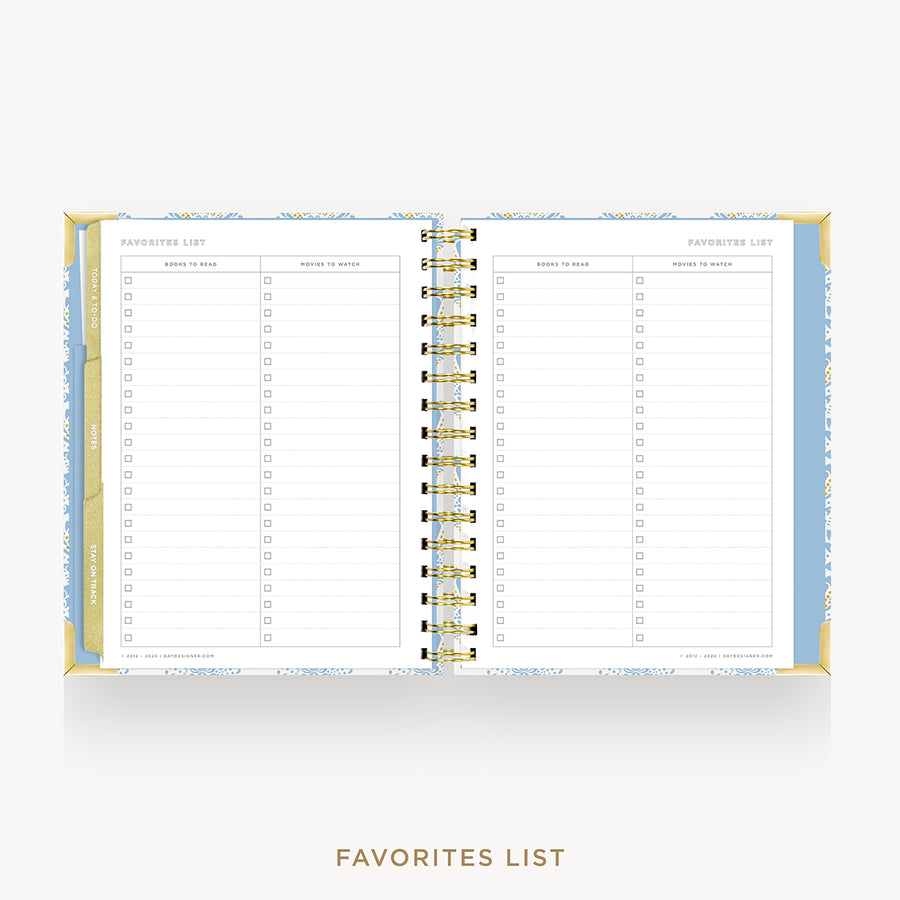 An open spiral-bound planner or agenda showing two lined pages labeled 'FAVORITES LIST' on a light gray background. The cover and inner borders have a pale blue and white pattern, and the spiral binding is gold.