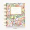 A Day Designer January 2027 planner, featuring a colorful watercolor illustration of Parisian houses, flowers, and greenery, with gold spiral binding and a cream title label.