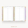 An open spiral-bound bucket list planner on a light gray background. The planner has a pastel floral border and gold-toned rings, with lined pages titled 'BEST BUCKET LIST' on both sides.