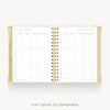 An open spiral-bound planner or notebook with gold-toned binding and white pages, showing a gift ideas to remember tracking table on the left and a blank page on the right, centered on a light gray background with the text 'GIFT IDEAS TO REMEMBER' below.