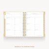 An open spiral-bound weekly planner page with gold-toned rings and a white page layout, shown on a light gray background with the text 'WEEKLY PLANNING PAGE' below.
