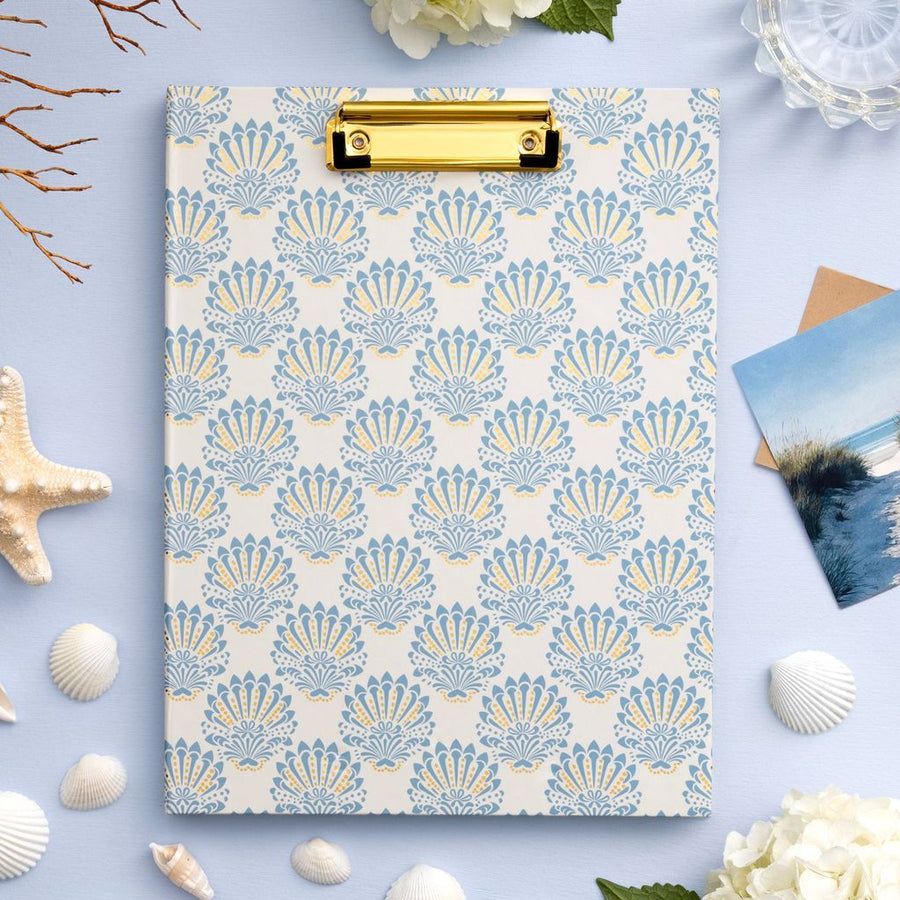 Clipboard with shell pattern on a light blue background with decorative elements.