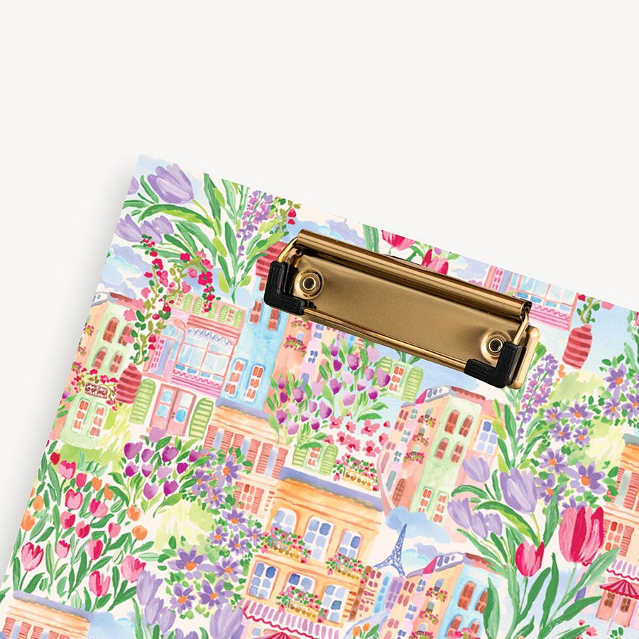 Clipboard with a colorful floral and village design on a white background