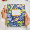 Floral notebook held by a person with a white background