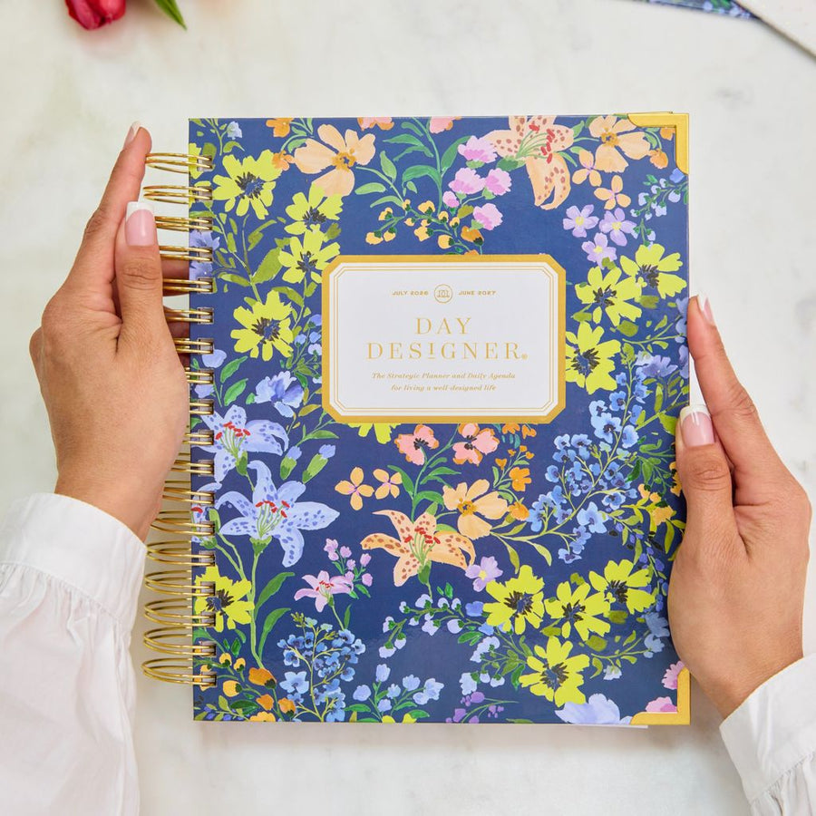 Floral notebook held by a person with a white background