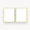 Open notebook with gold spiral binding on a white background