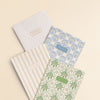 Set of four notebooks with different designs on a beige background