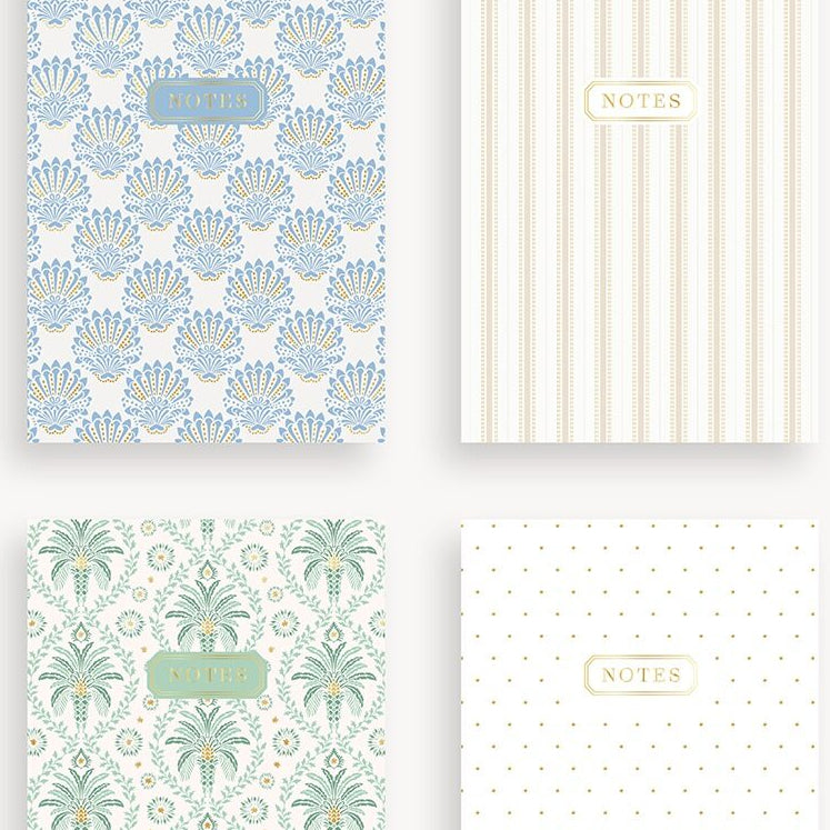 Four patterned notebooks with different designs on a white background