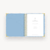 light blue and gold notebook open to light blue liner, day designer cover page