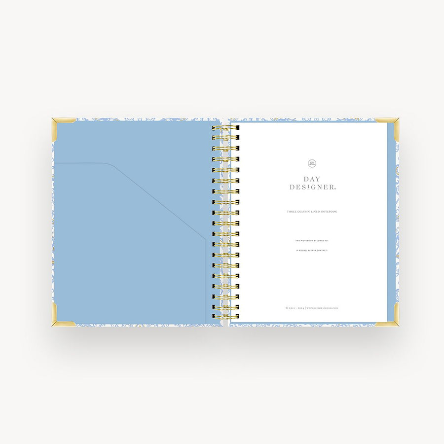 light blue and gold notebook open to light blue liner, day designer cover page