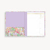 Purple planner with colorful floral design on a white background