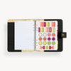 Open black A5 binder to show black and gold lining and binding, notes pages and colorful stickers