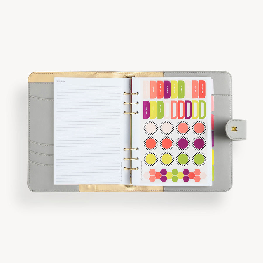 open gray A5 binder with notes pages, colorful stickers, snap closure and gold day designer logo