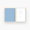 light blue and gold mini notebook open to light blue liner, day designer cover page